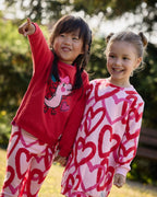 Tuc Tuc kırmızı dinozorlu sweatshirt ve kalpli tayt takımı kız çocuk üzerinde önden; parkta arkadaşıyla birlikte.
