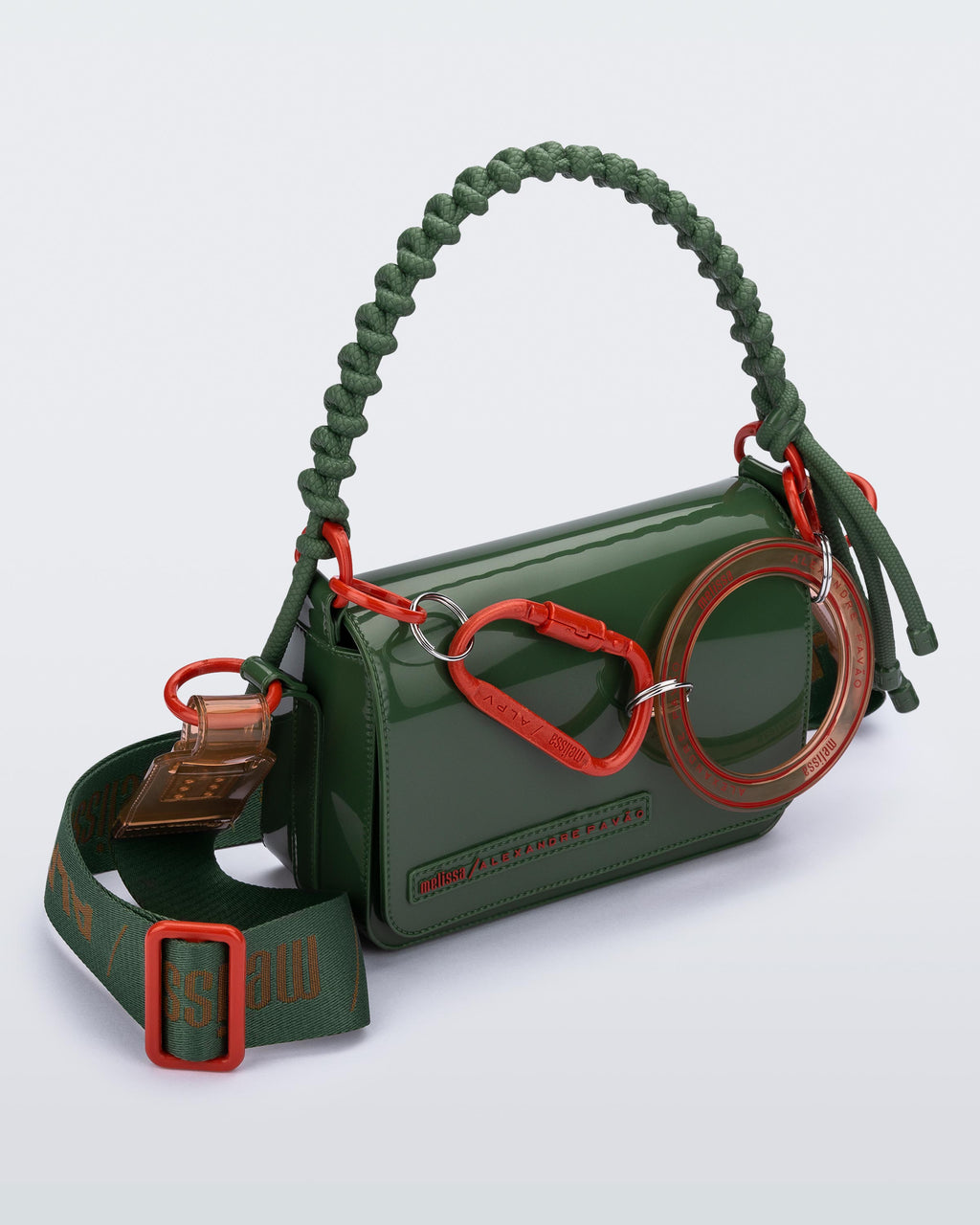 Melissa Alexandre Pavão Olga Bag koyu yeşil, turuncu karabina detaylı ve yeşil halat saplı designer çanta. Ön yüzeyde kabartmalı logo detayı.