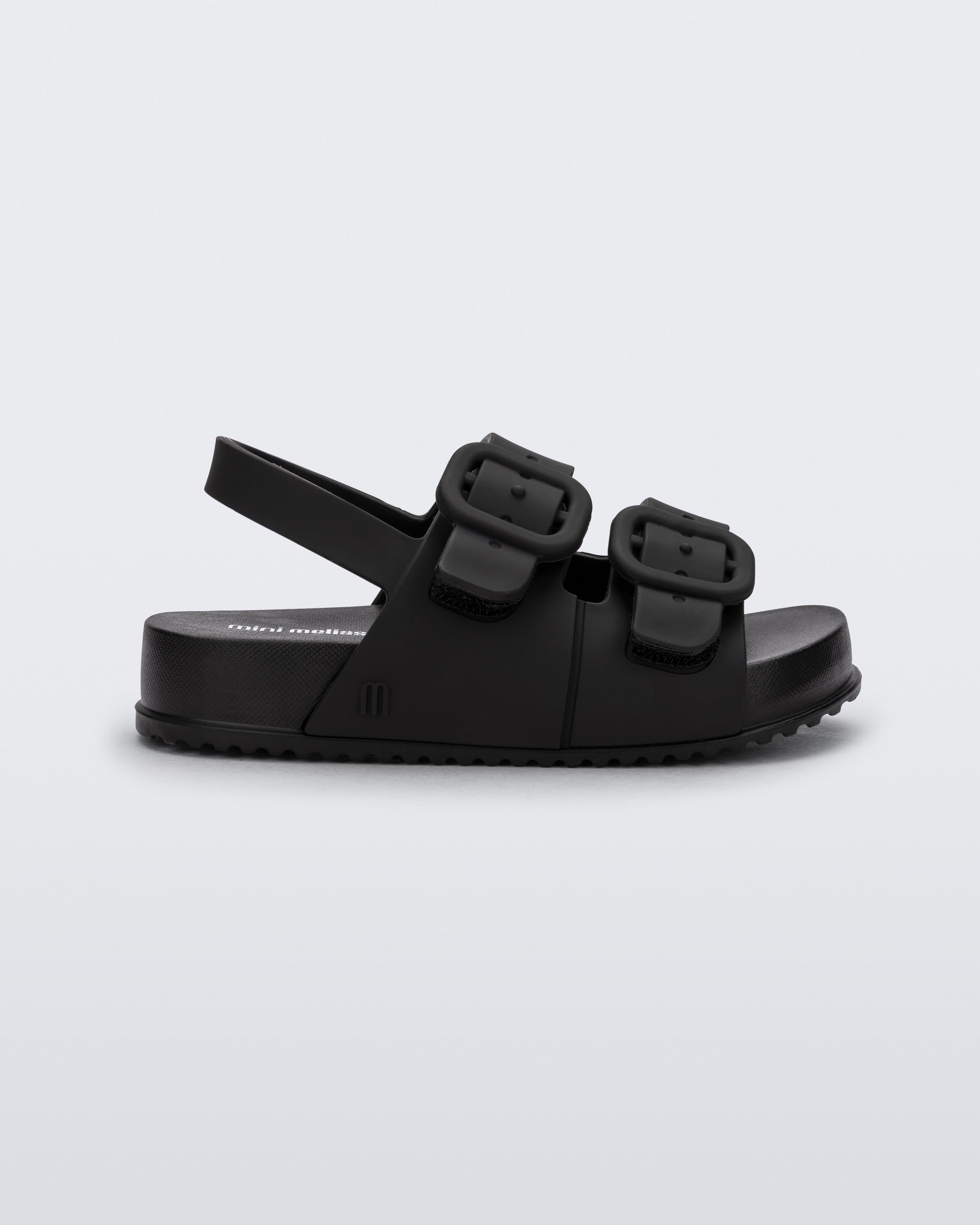 Mini Melissa Cozy Sandal Baby yan görünüm, mat siyah renkli kalın tabanlı bebek sandalet, tokalı görünümlü gizli cırt cırtlı (velcro) pratik kapama detayı.