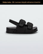 Mini Melissa Cozy Sandal Baby yan görünüm, mat siyah renkli kalın tabanlı bebek sandalet, tokalı görünümlü gizli cırt cırtlı (velcro) pratik kapama detayı.