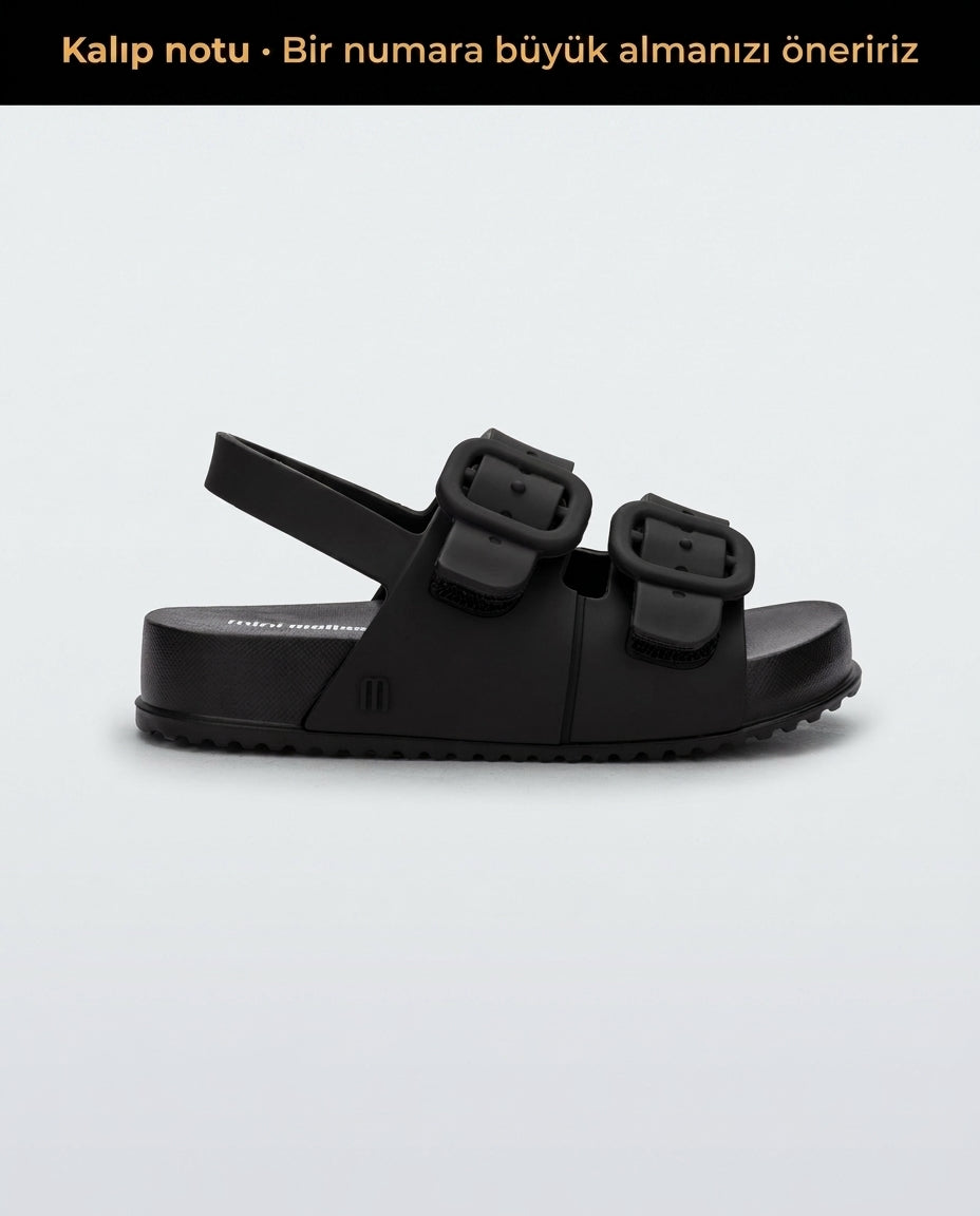 Mini Melissa Cozy Sandal Baby yan görünüm, mat siyah renkli kalın tabanlı bebek sandalet, tokalı görünümlü gizli cırt cırtlı (velcro) pratik kapama detayı.