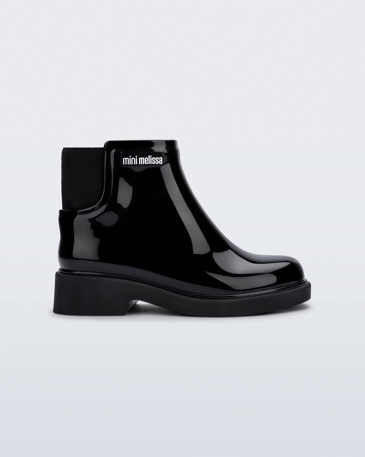 Mini Melissa Chelsea Boot II siyah çocuk botu, parlak yüzeyi ve elastik yan panel detayıyla yan açıdan görünüyor.