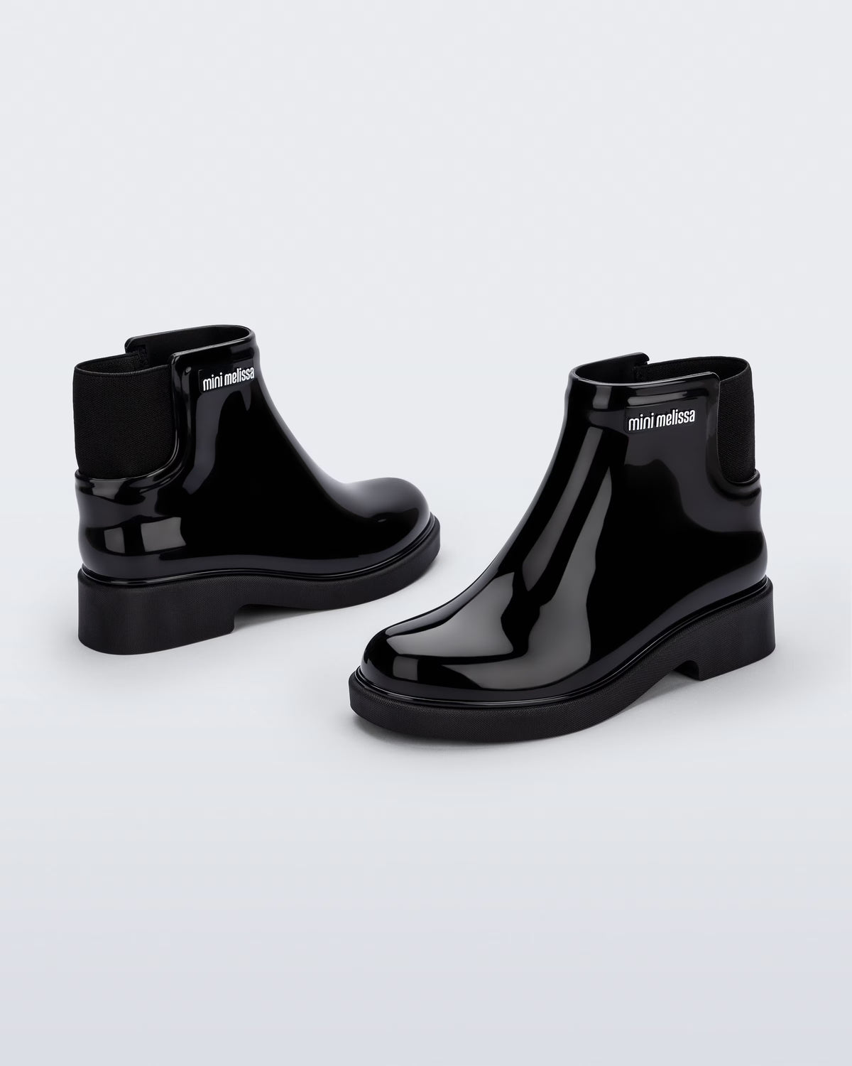 Siyah Mini Melissa Chelsea Boot II çocuk çifti üstten açıyla; örgü bilek manşeti net şekilde öne çıkıyor.