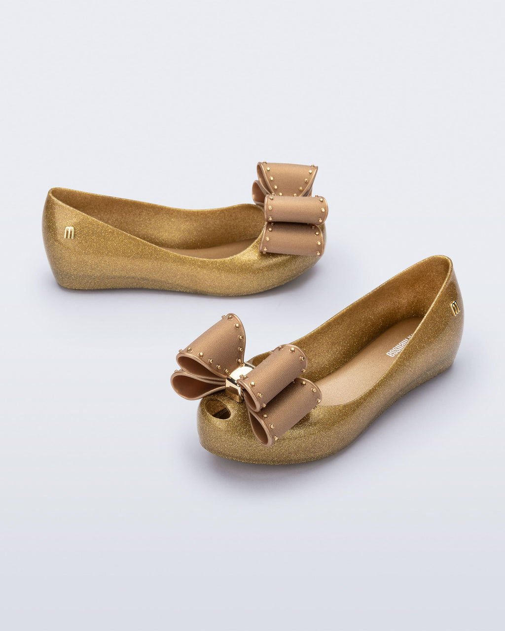 Mini Melissa Classic Bow altın metalik junior babet, yapılandırılmış fiyonk ve metal aksesuar detayı