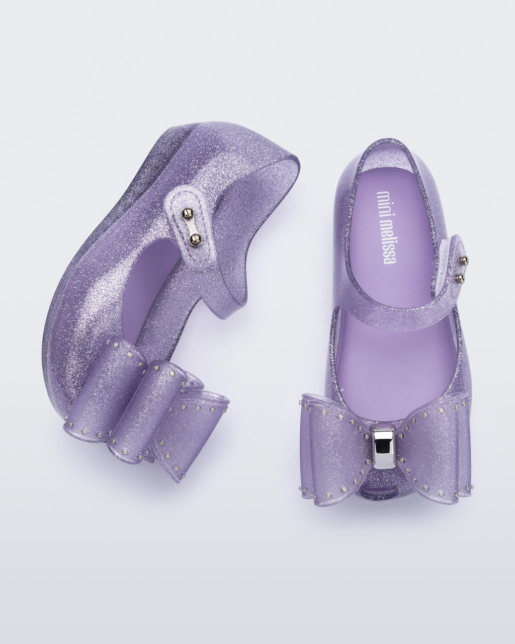 Mini Melissa Ultragirl lila simli babet üstten görünüm büyük fiyonk aplikesi ve velcro sistem detayı
