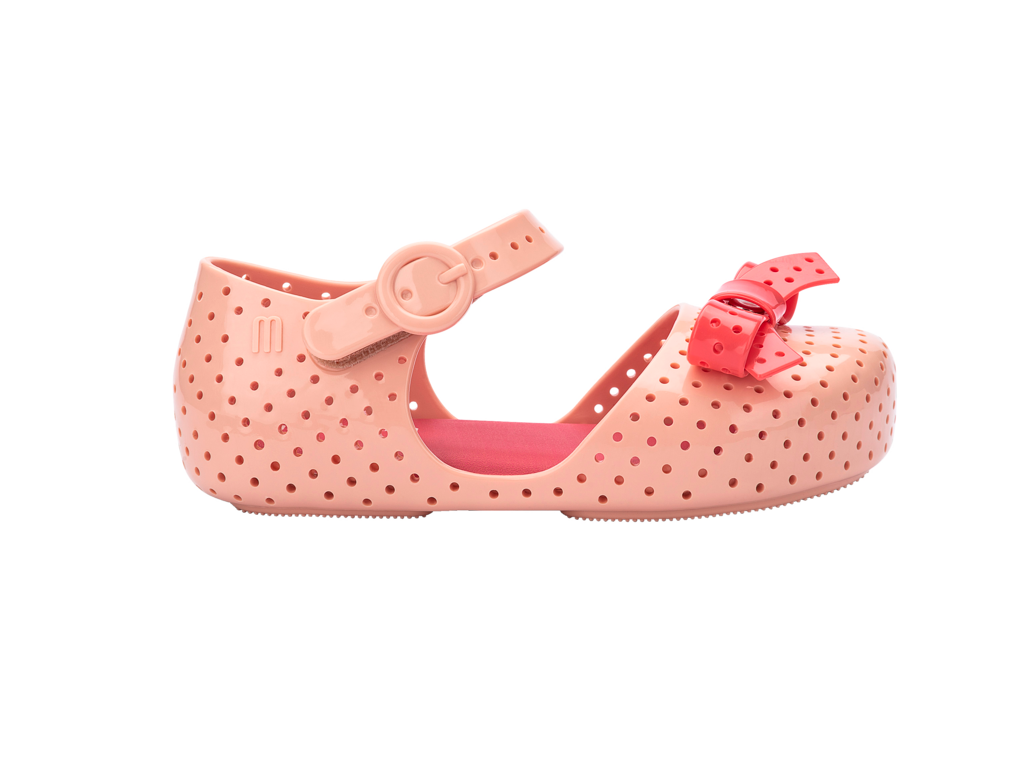 Mini Melissa Furadinha Pop BB bej kırmızı çocuk ayakkabı yan görünüm, nefes alabilir delikli yapı ve kırmızı fiyonk vurgusu