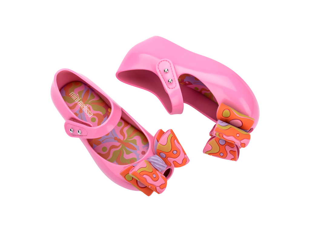 Mini Melissa Ultragirl Wonderland BB pembe çocuk ayakkabı – üstten görünüm, turuncu renkli büyük fiyonk detaylı, renkli iç taban tasarımlı, cırt cırt bantlı pratik model