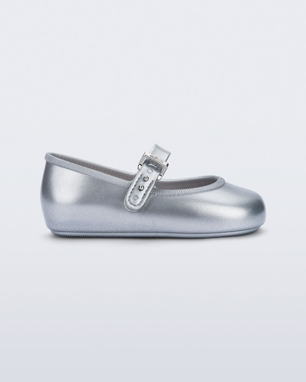 Mini Melissa Soft Ballerina simli gümüş babet, metalik tokalı kayışıyla yan açıdan görünüyor.