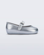 Mini Melissa Soft Ballerina simli gümüş babet, metalik tokalı kayışıyla yan açıdan görünüyor.