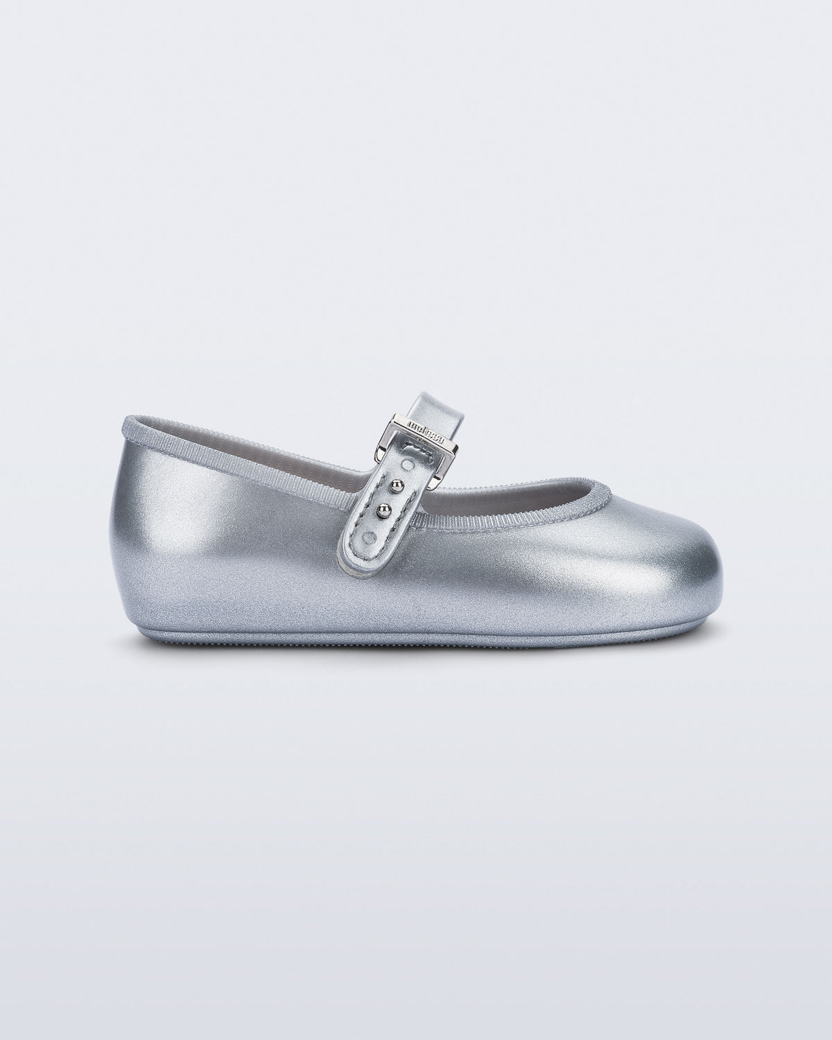 Mini Melissa Soft Ballerina simli gümüş babet, metalik tokalı kayışıyla yan açıdan görünüyor.