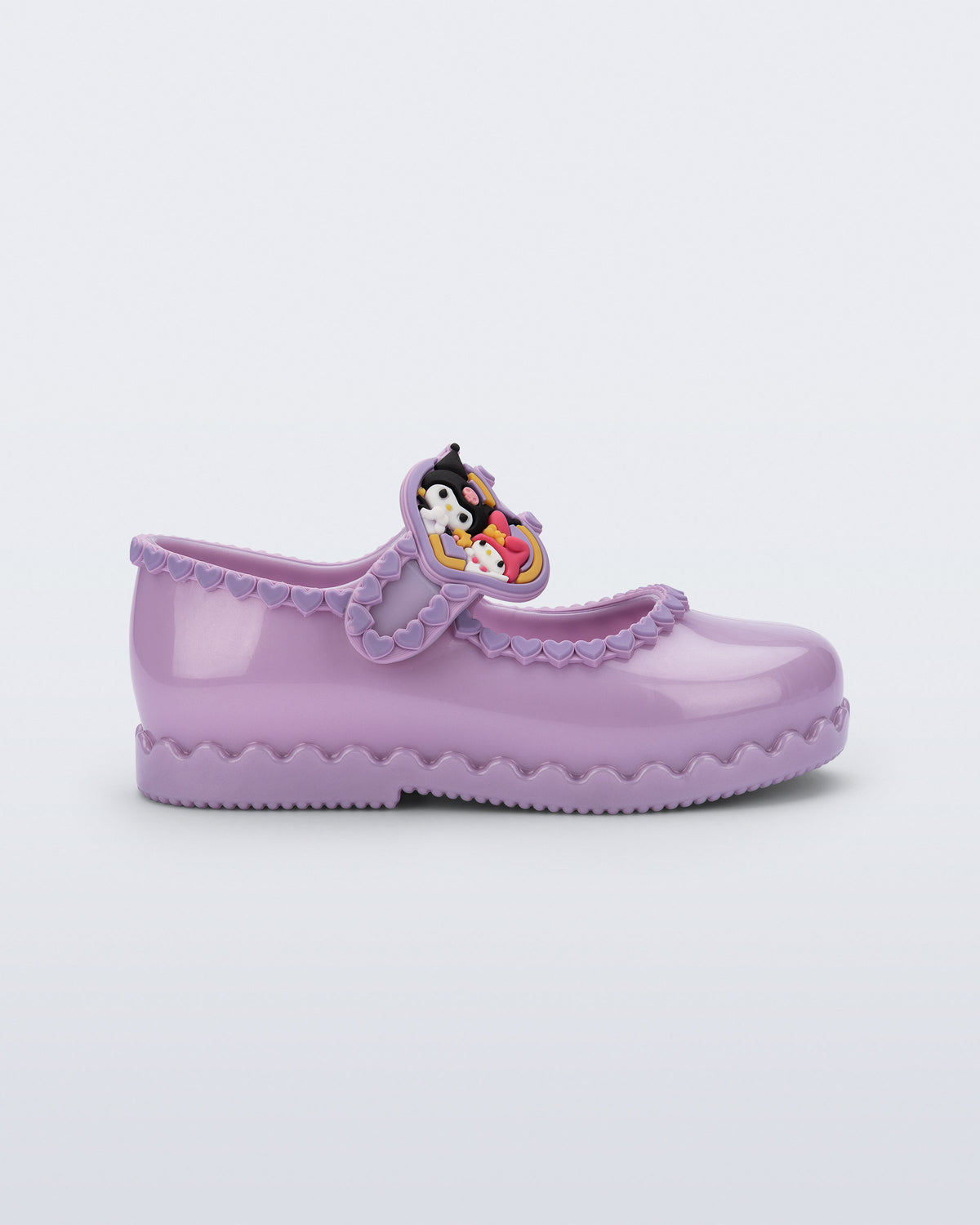 Mini Melissa Hip Ballerina lila babet, Kuromi ve My Melody figürlü kalp rozetiyle yan açıdan görünüyor.