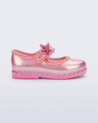 Mini Melissa Hip Ballerina Star metalik pembe babet, glitter yıldız rozetiyle yan açıdan görünüyor.