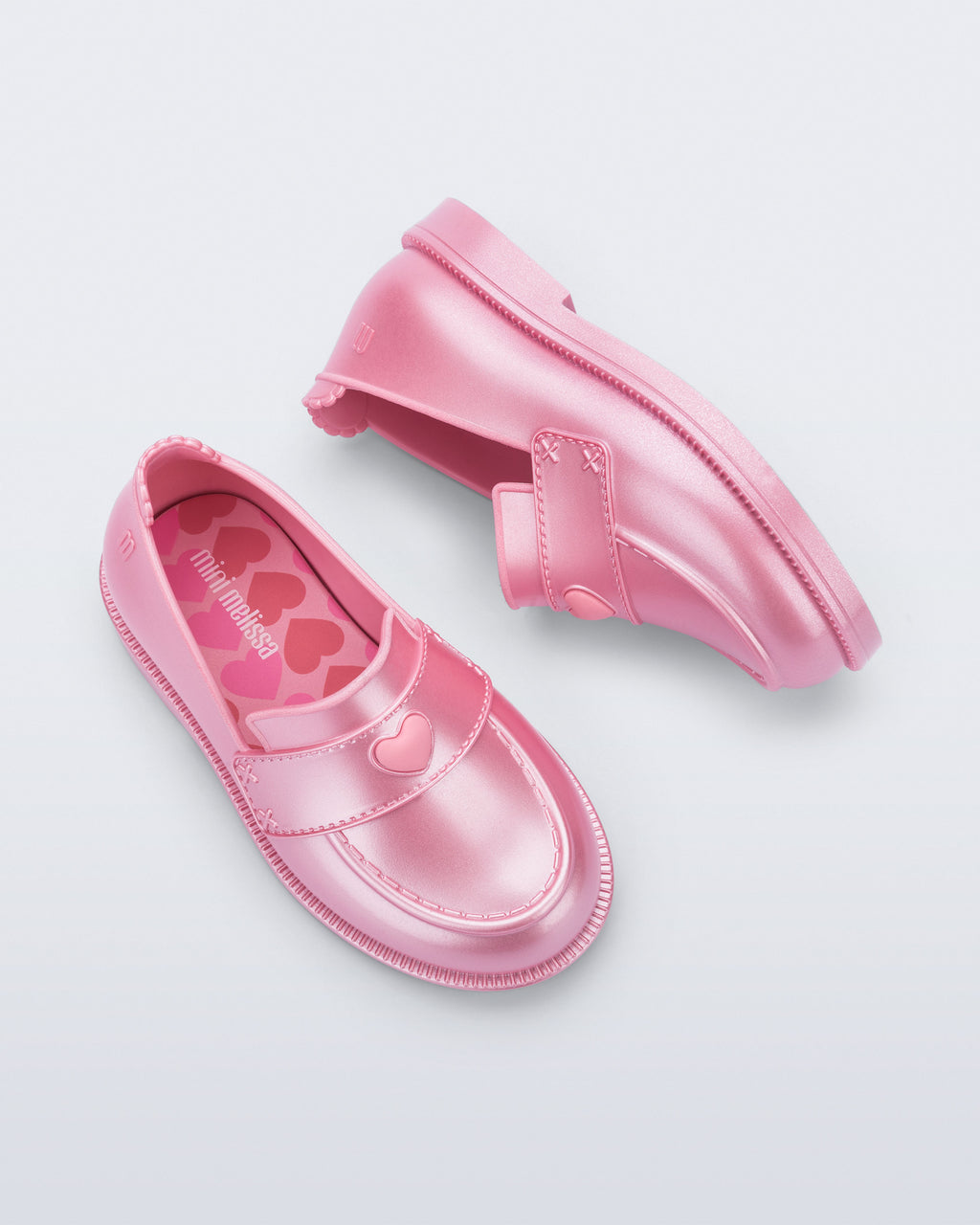 Mini Melissa Royal Love babetin kalp rozet ve dikişli strap detayı yakın planda görünüyor.