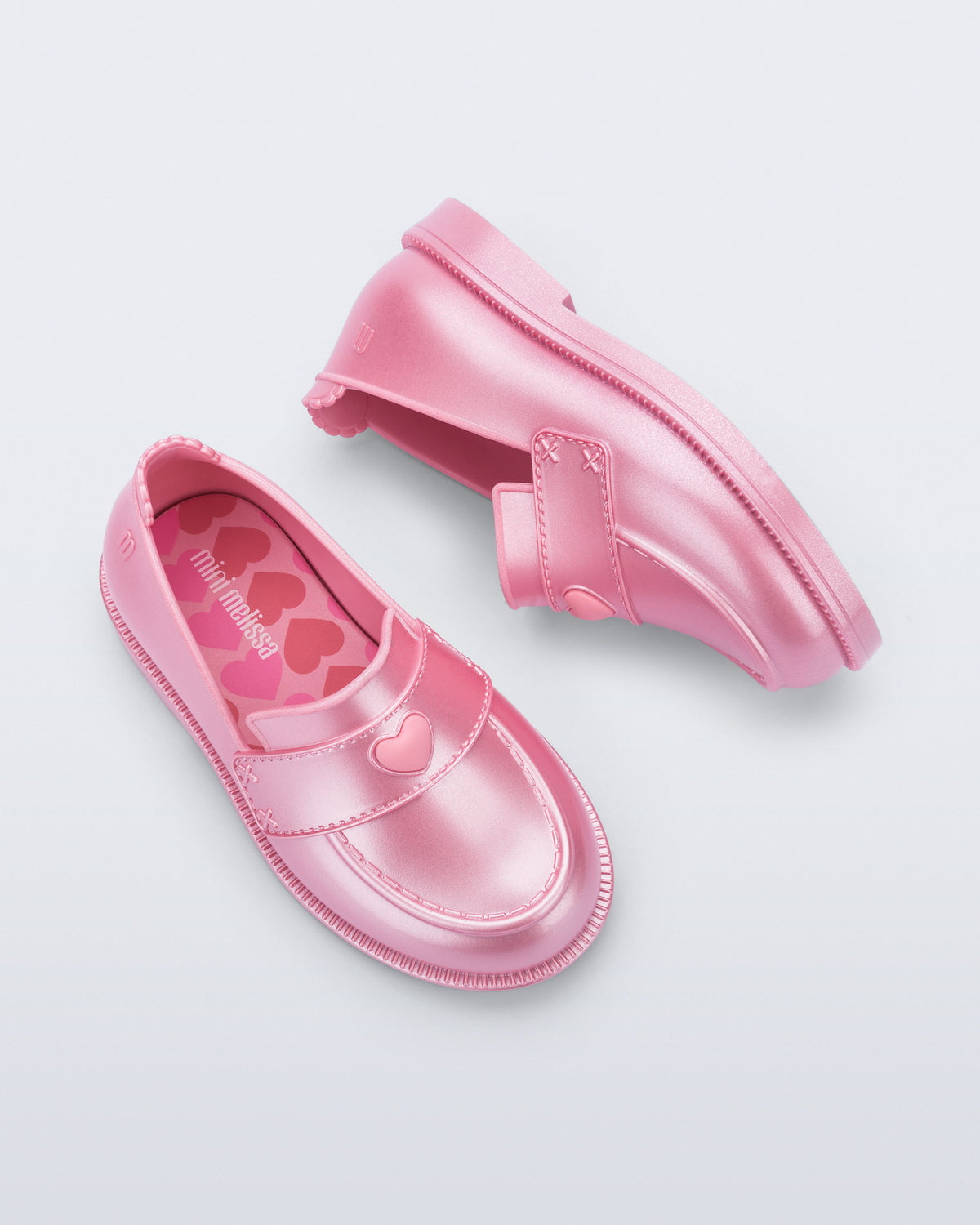 Mini Melissa Royal Love babetin kalp rozet ve dikişli strap detayı yakın planda görünüyor.