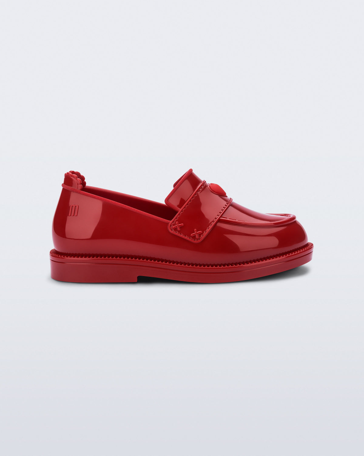Mini Melissa Royal Love kırmızı babet, kalp rozetli loafer tasarımıyla yan açıdan görünüyor.
