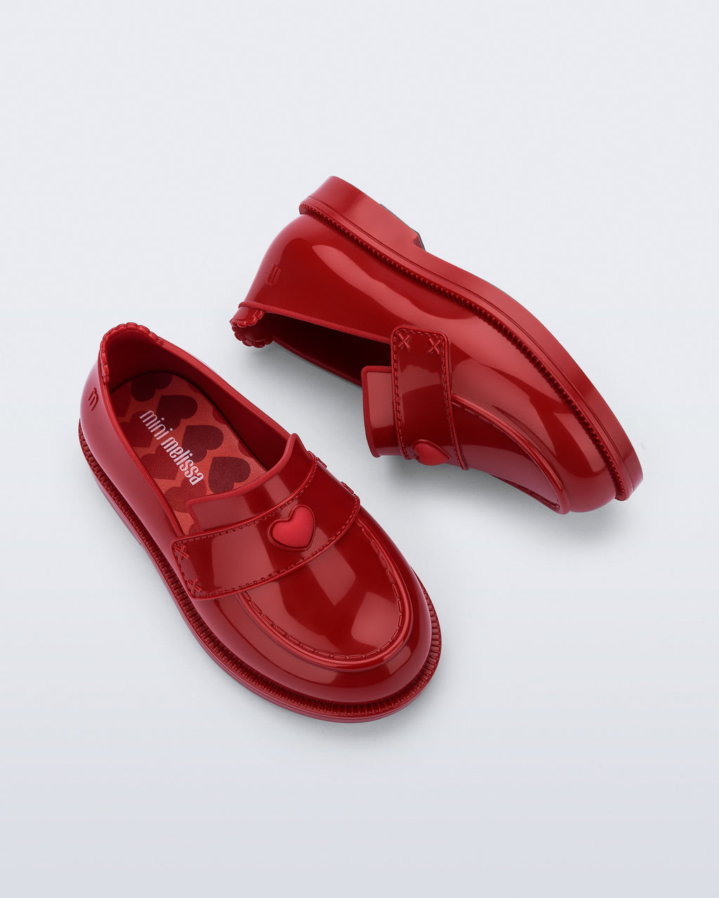 Mini Melissa Royal Love babetin kalp rozet ve dikişli strap detayı yakın planda görünüyor.