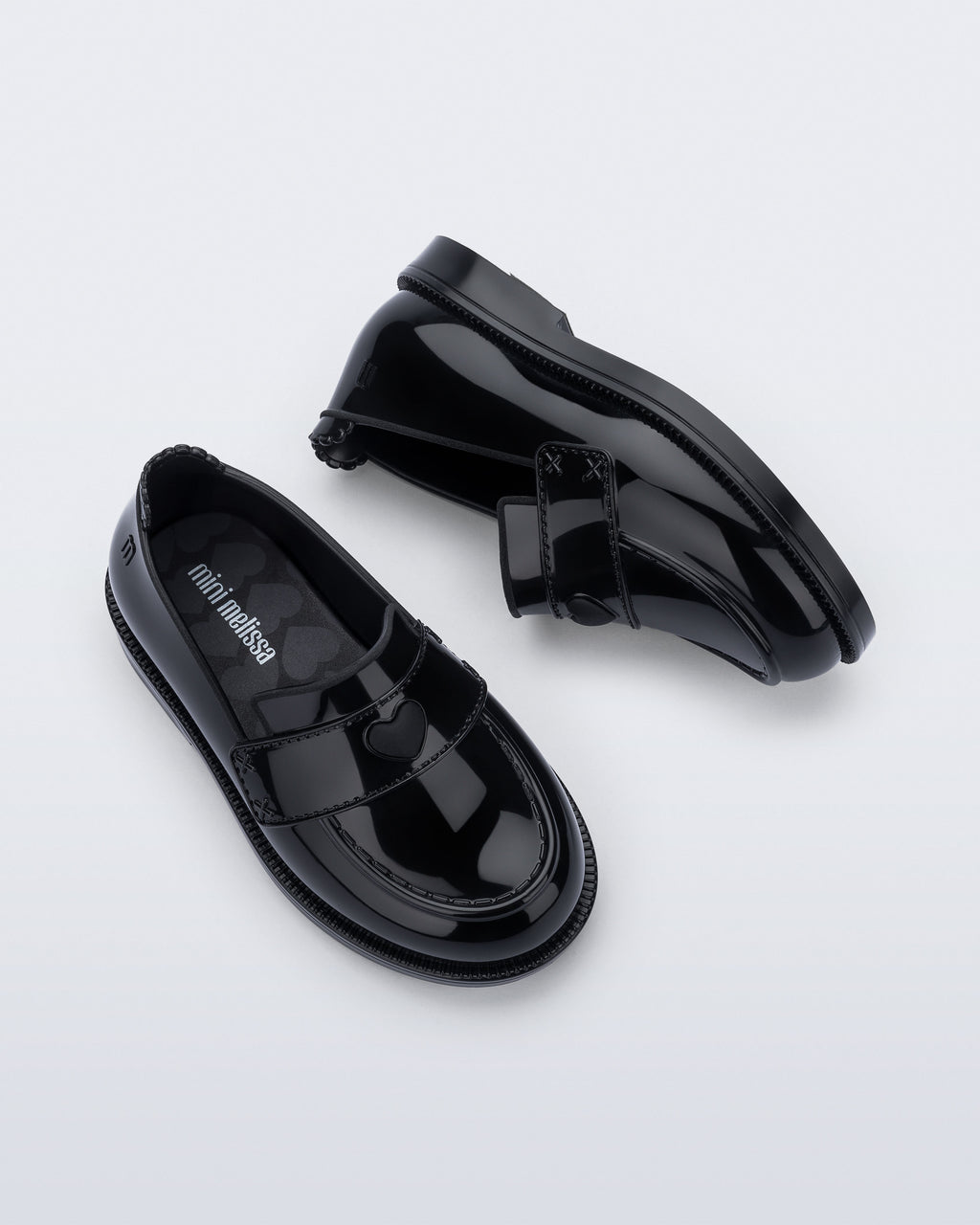 Mini Melissa Royal Love babetin kalp rozet ve dikişli strap detayı yakın planda görünüyor.