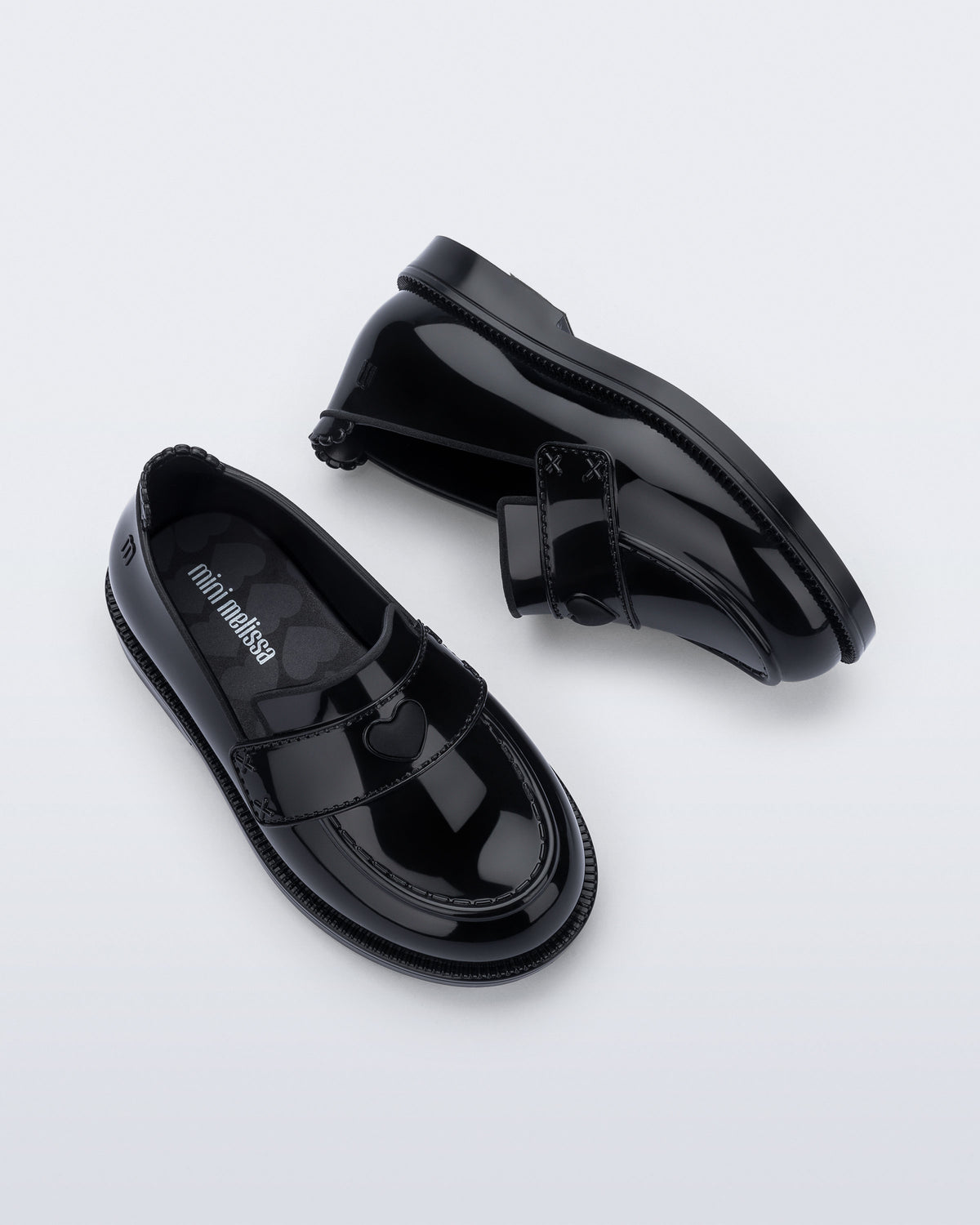 Mini Melissa Royal Love babetin kalp rozet ve dikişli strap detayı yakın planda görünüyor.