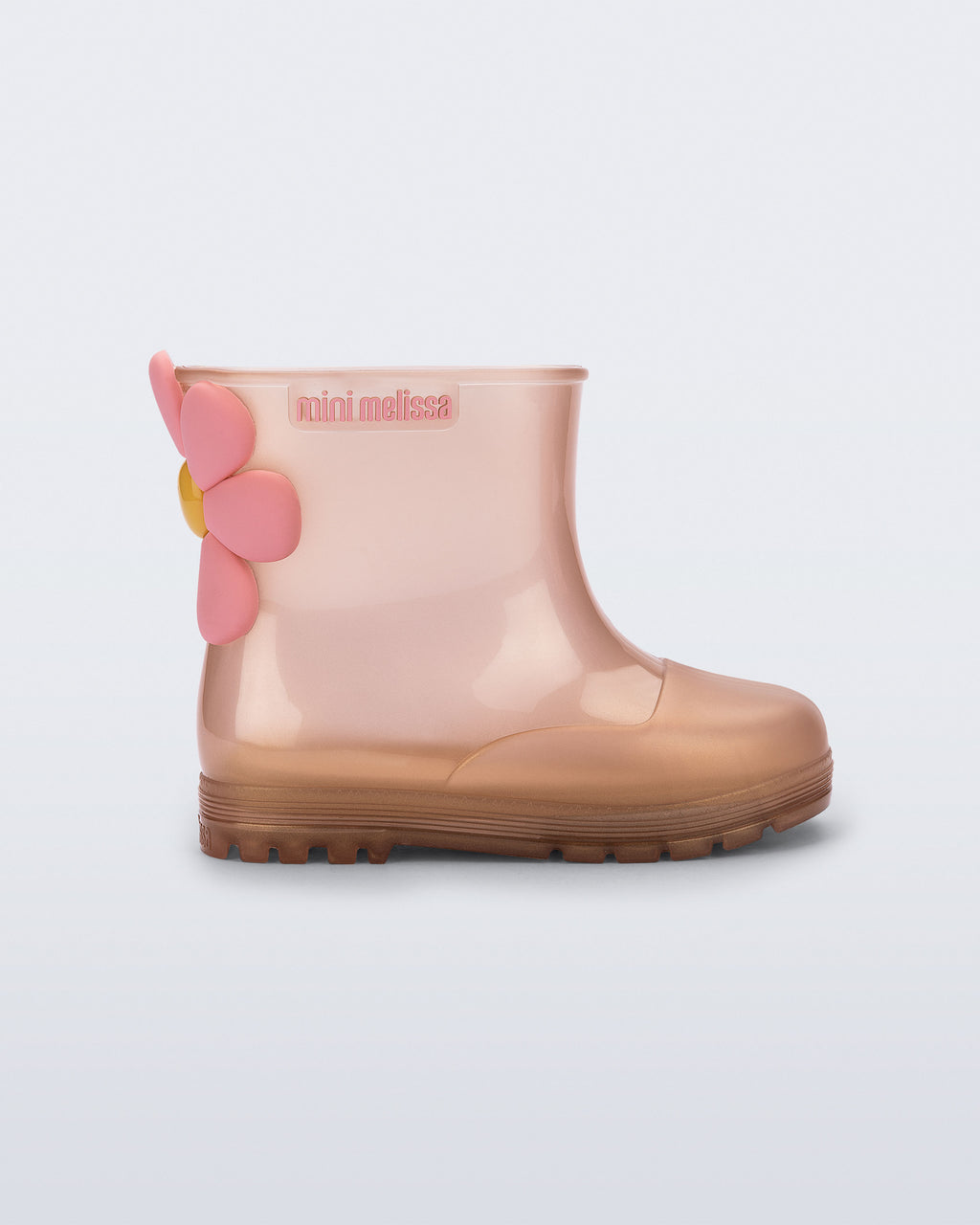 Mini Melissa Welly Bloomy pembe bakır ombre yağmur botu, 3 boyutlu çiçek aplikesiyle yan açıdan görünüyor.