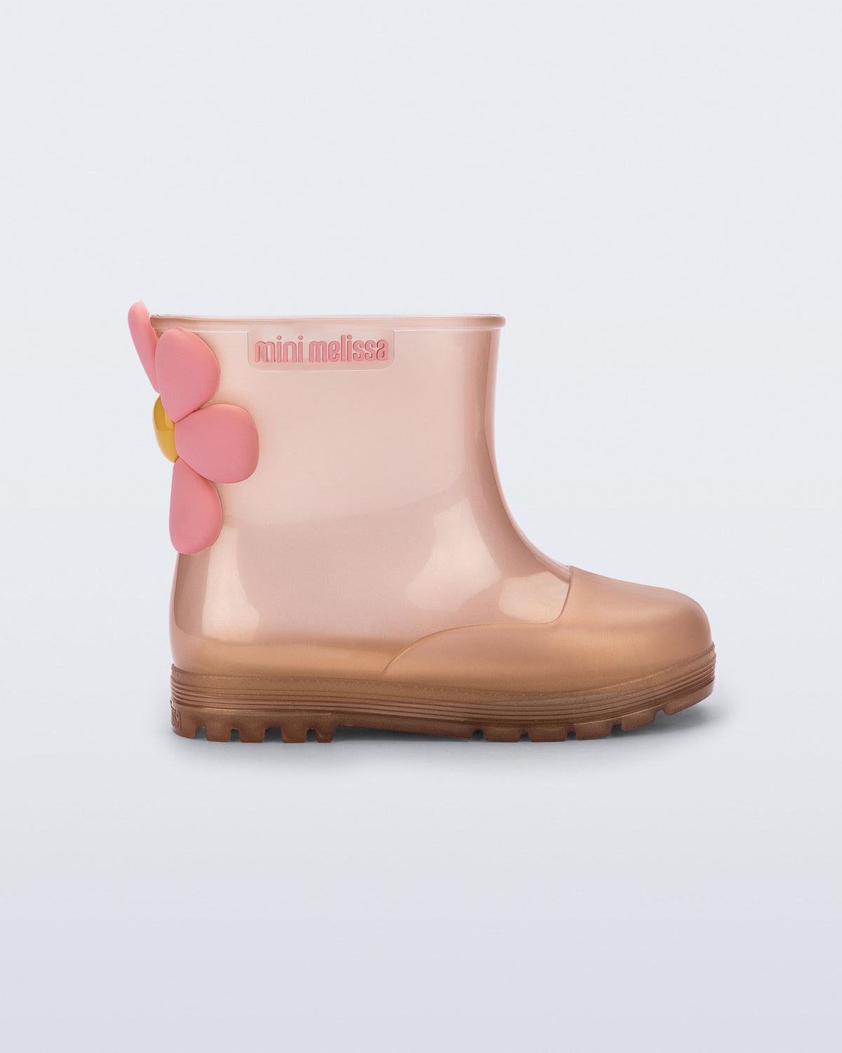 Mini Melissa Welly Bloomy pembe bakır ombre yağmur botu, 3 boyutlu çiçek aplikesiyle yan açıdan görünüyor.