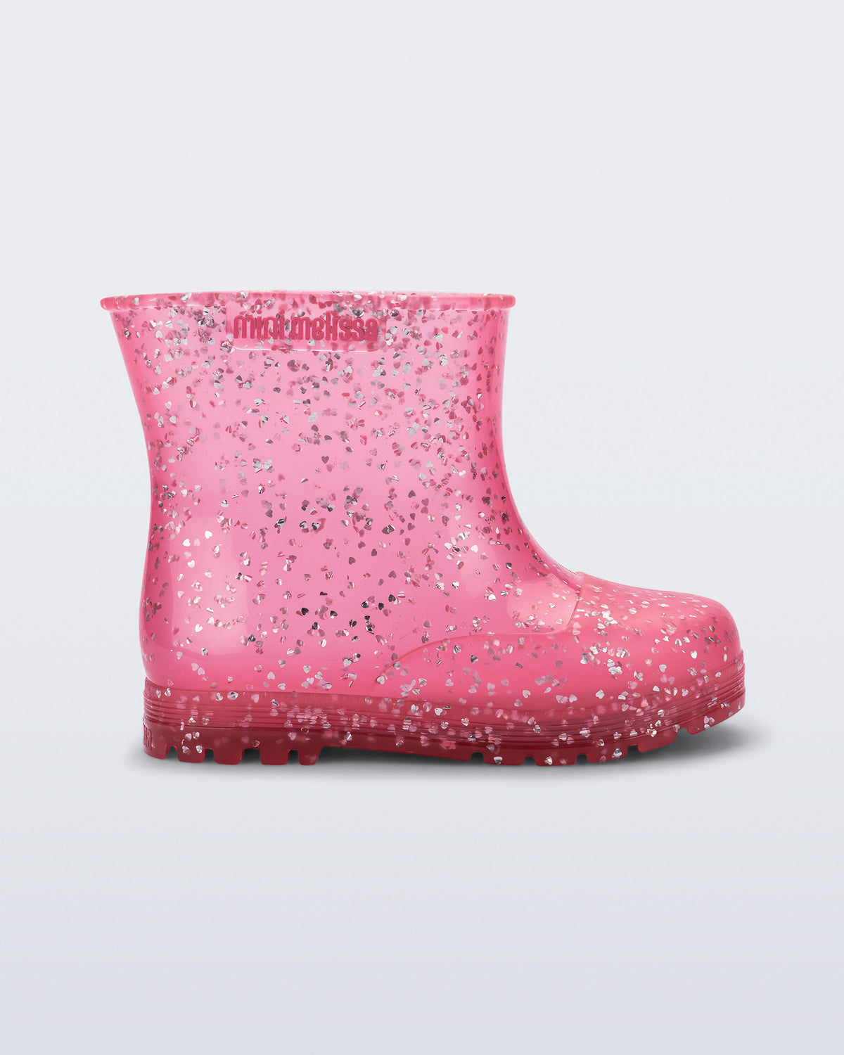 Mini Melissa Welly Shiny Elements pembe yağmur botu, gömülü kalp simli dokusuyla yan açıdan görünüyor.