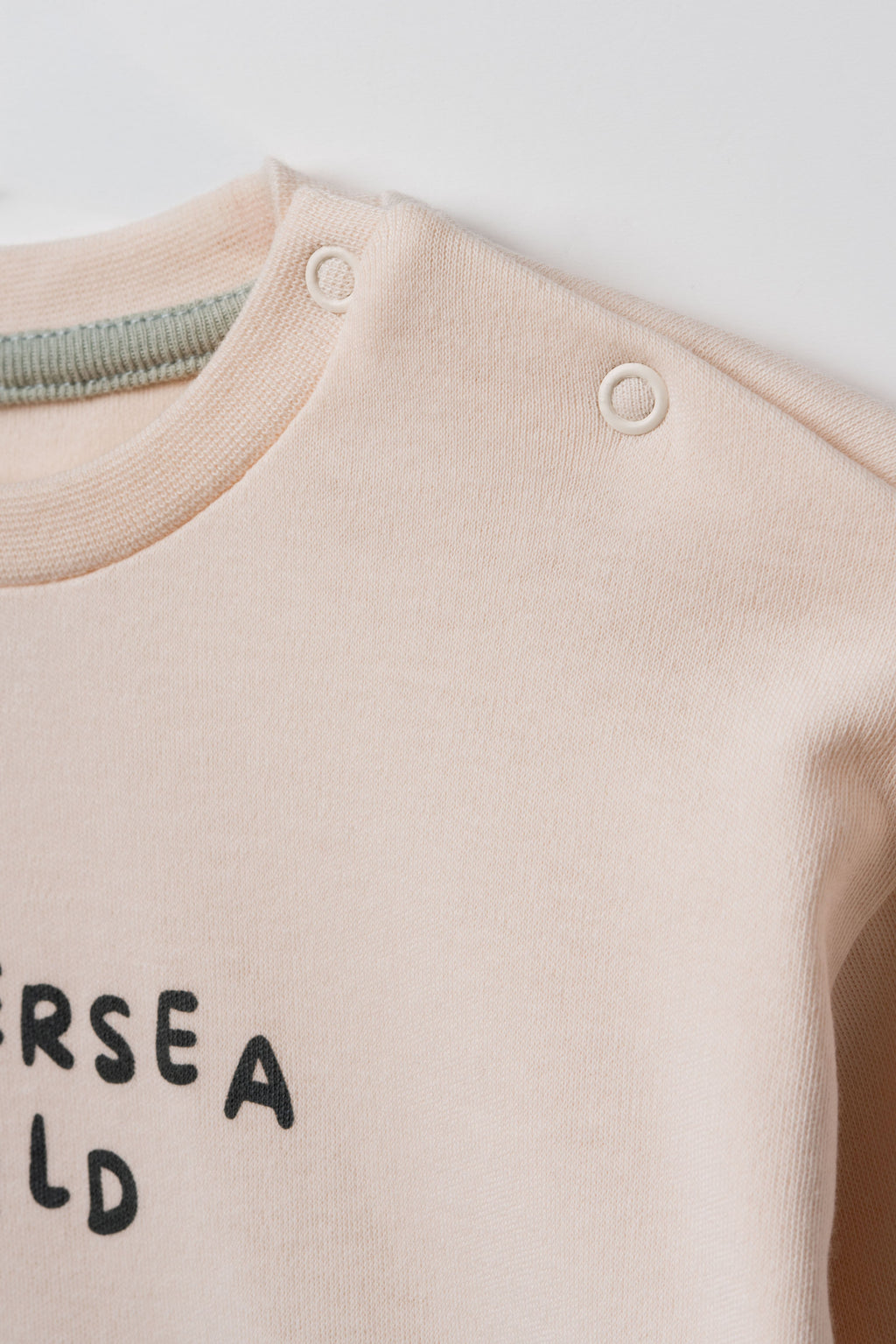 GOTS sertifikalı organik pamuk bebek sweatshirtü yaka detayı, nikel içermeyen çıtçıt kapama yakın plan