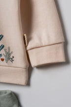 Pudra peach organik pamuk bebek sweatshirtü kol detayı, ribana manşet ve yumuşak interlok kumaş yakın çekim