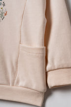 Pudra peach organik pamuk bebek sweatshirtü yan cep detayı, ribana manşet ve yumuşak interlok kumaş yakın çekim