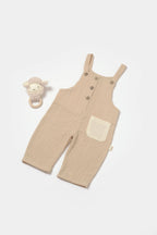 BabyCosy bej cepli müslin salopet, yanında kuzu figürlü diş kaşıyıcı ile