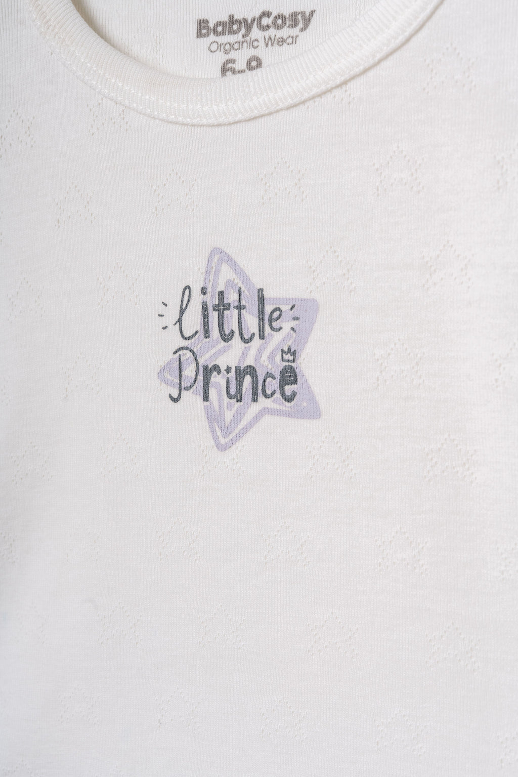 Ekru organik pamuk pointel üst üzerindeki "Little Prince" yazı detayı ve yıldız formundaki nefes alabilir doku