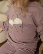 Dirkje lila sweatshirt kız çocuk üzerinde yakın planda; bubble tea baskısının kabartmalı krem köpük dokusu görünüyor.