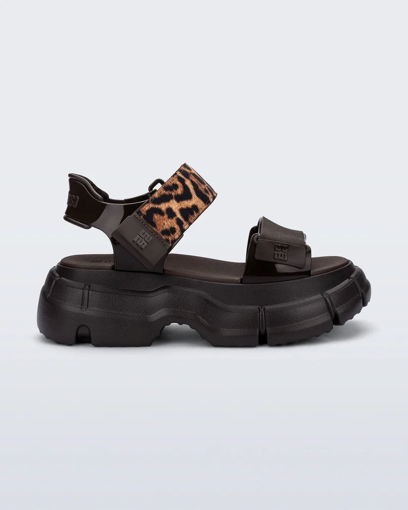 Melissa Pulse kahverengi platform sandalet, leopar desenli ayarlanabilir üst bant ile yan profil görünümü. Modern ve sportif tasarım, rahat taban.
