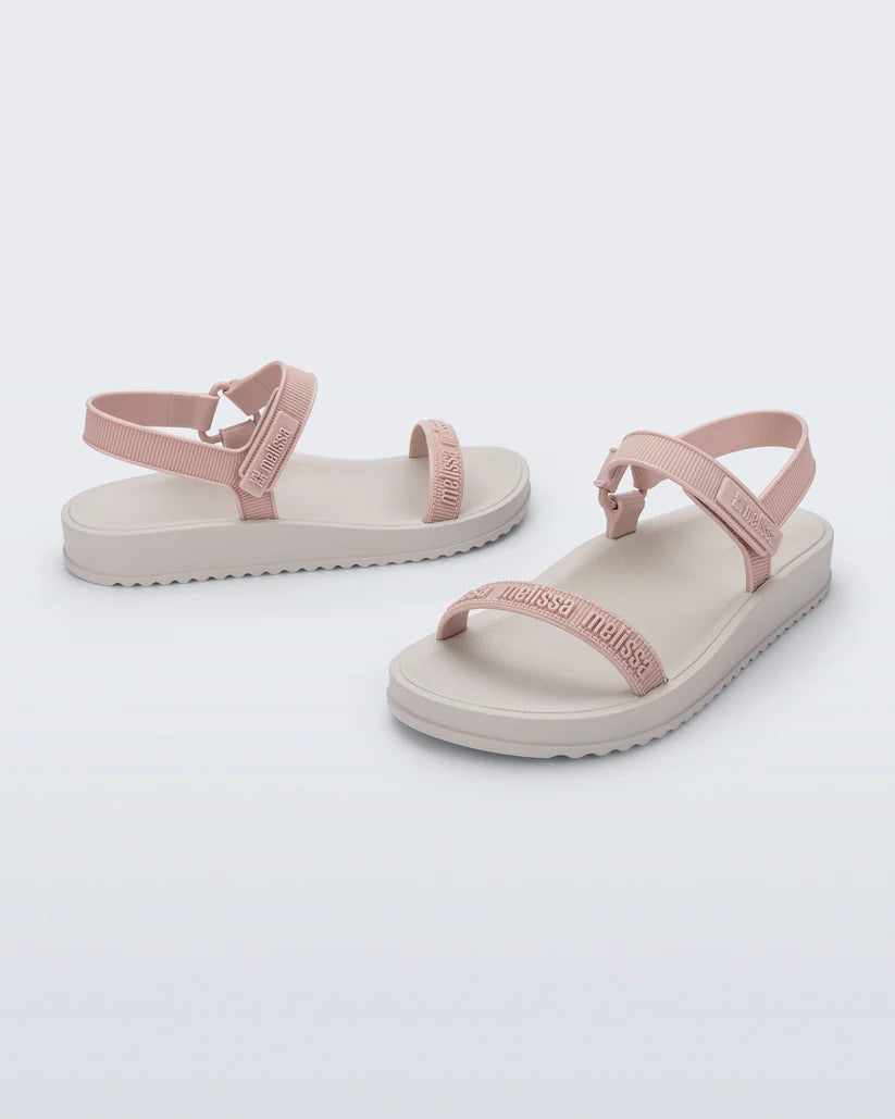Kabartma logolu pembe bantlara ve modern beyaz tabana sahip efor sarf edilmemiş günlük şehir şıklığı Melissa M-Lover Papete sandalet çapraz görünüm