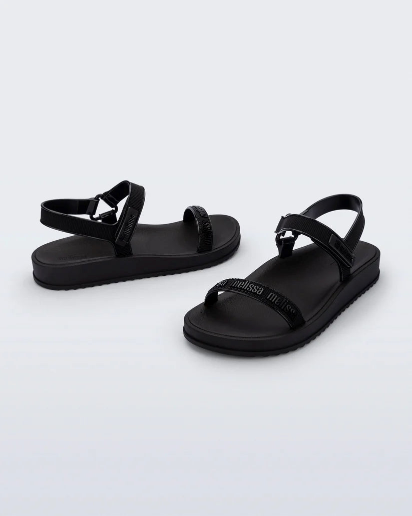 Kabartma logolu ve özel dokulu bantlara sahip kentsel stil Melissa M-Lover Papete siyah sandalet çapraz görünüm