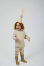 Miela Kids bej kapitone sweatshirt, model üzerinde aynı renk pantolon ve yıldızlı şapkayla