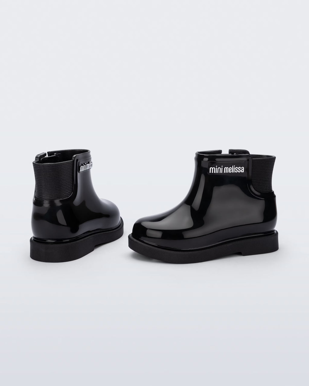 Siyah Mini Melissa Chelsea Boot II çifti üstten açıyla; örgü bilek manşeti net şekilde öne çıkıyor.