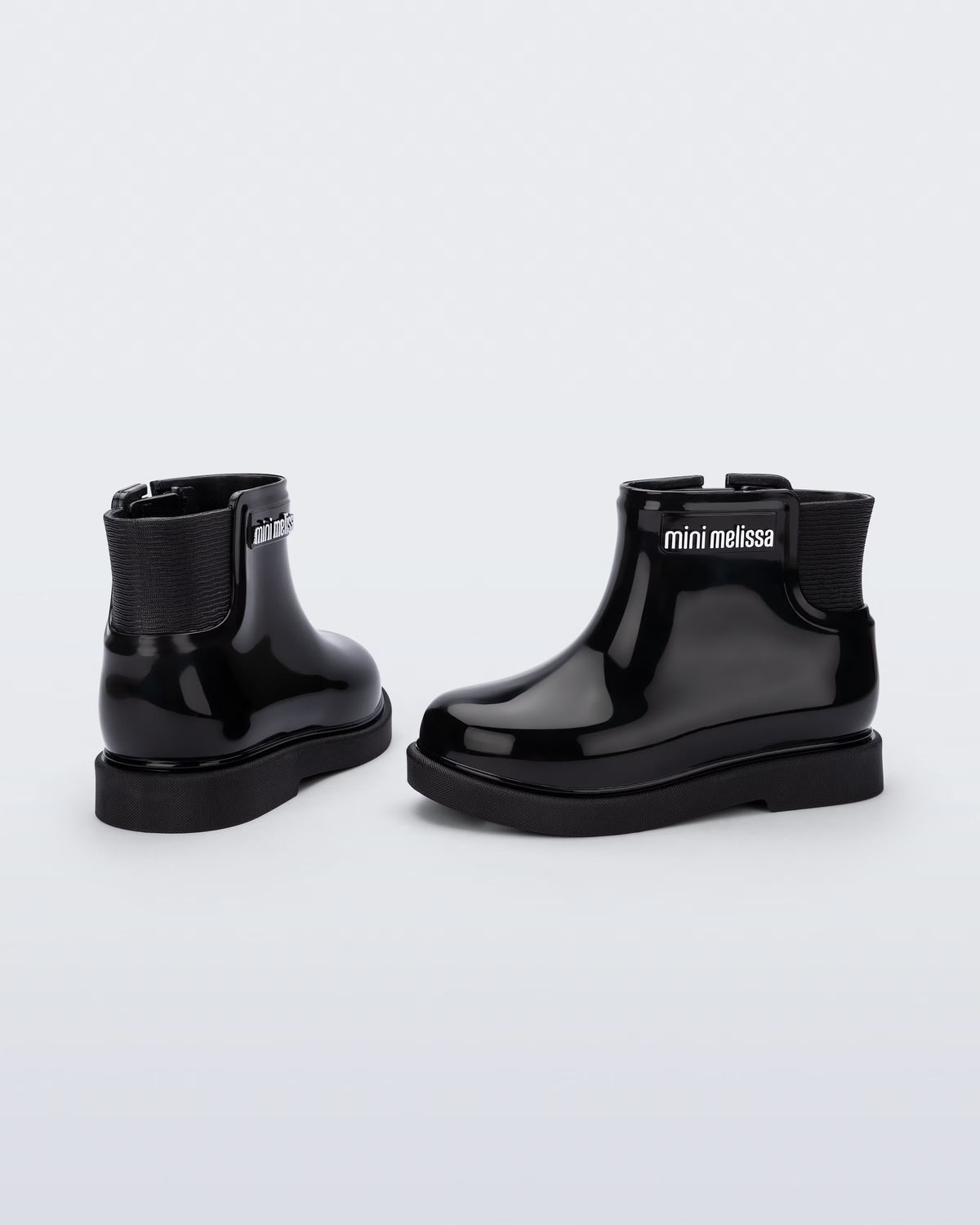 Siyah Mini Melissa Chelsea Boot II çifti üstten açıyla; örgü bilek manşeti net şekilde öne çıkıyor.