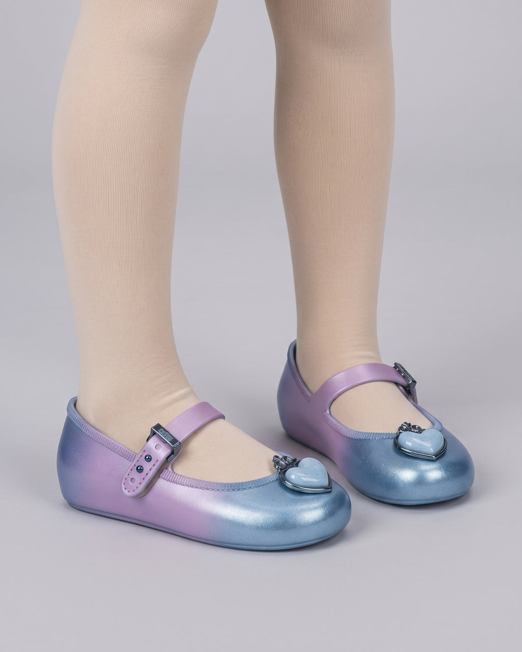 Mini Melissa mavi kız çocuk ayakkabısı, yandan görünümde lila-mavi renk geçişi, ekru mus çorapla kombinlenmiş