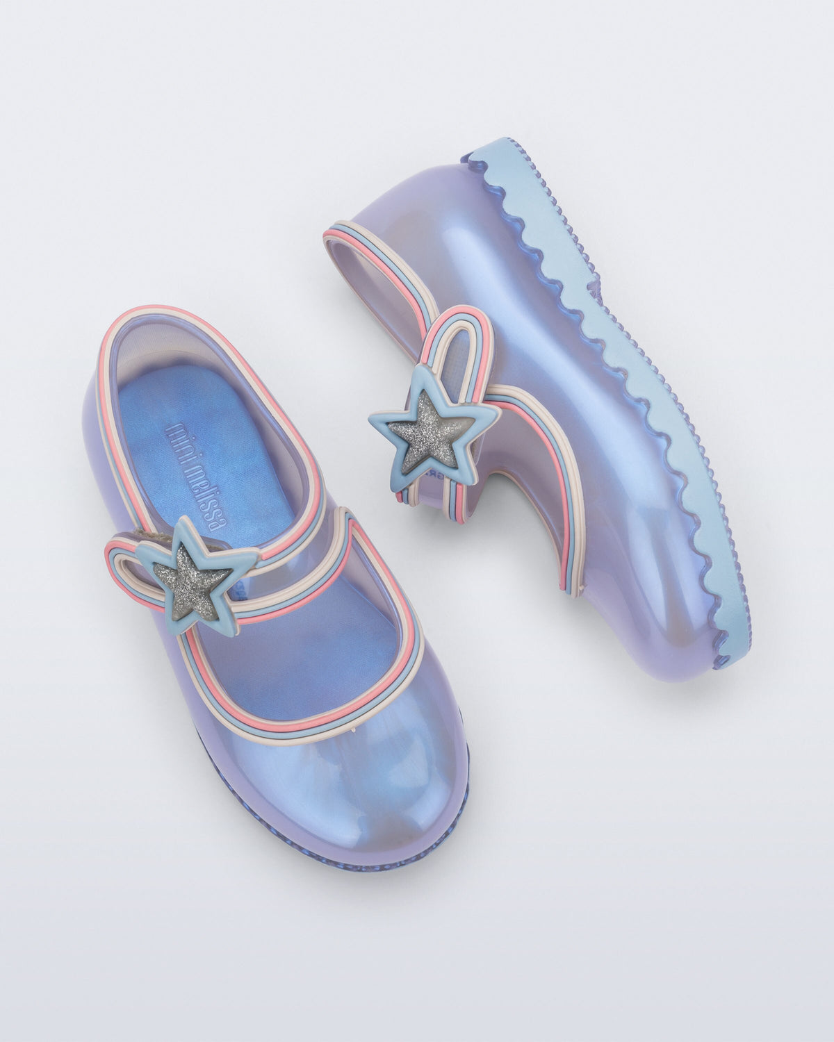 Sedefli mavi Mini Melissa Hip Ballerina Star çifti üstten açıyla; simli yıldız rozet ve dalgalı taban kenarı görünüyor.