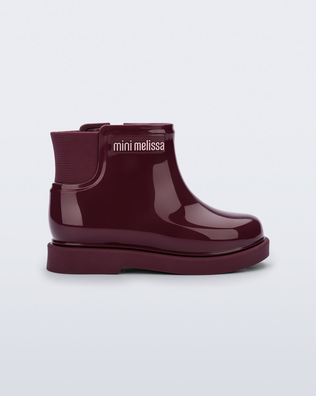 Mini Melissa bordo kız çocuk bot, yandan görünüm; parlak rugan görünümlü gövdesi, elastik yan körüğü ve kalın mat tırtıklı tabanı.