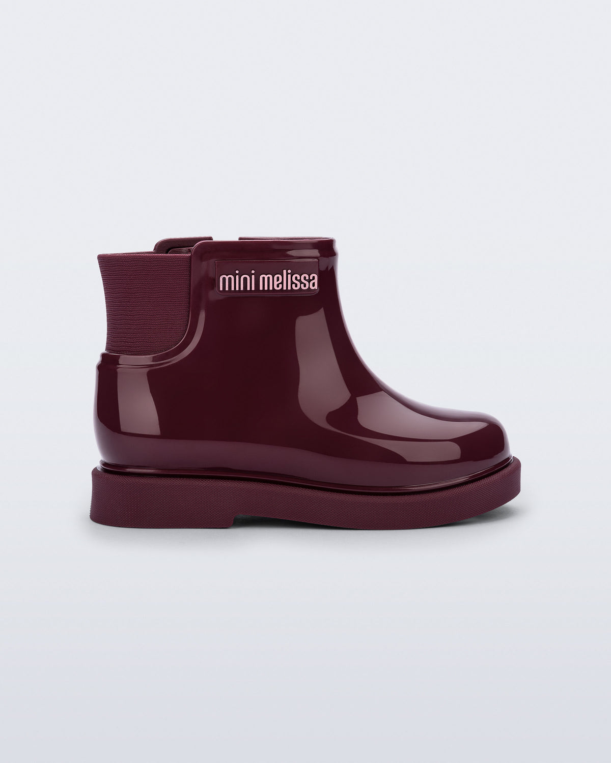 Mini Melissa bordo kız çocuk bot, yandan görünüm; parlak rugan görünümlü gövdesi, elastik yan körüğü ve kalın mat tırtıklı tabanı.