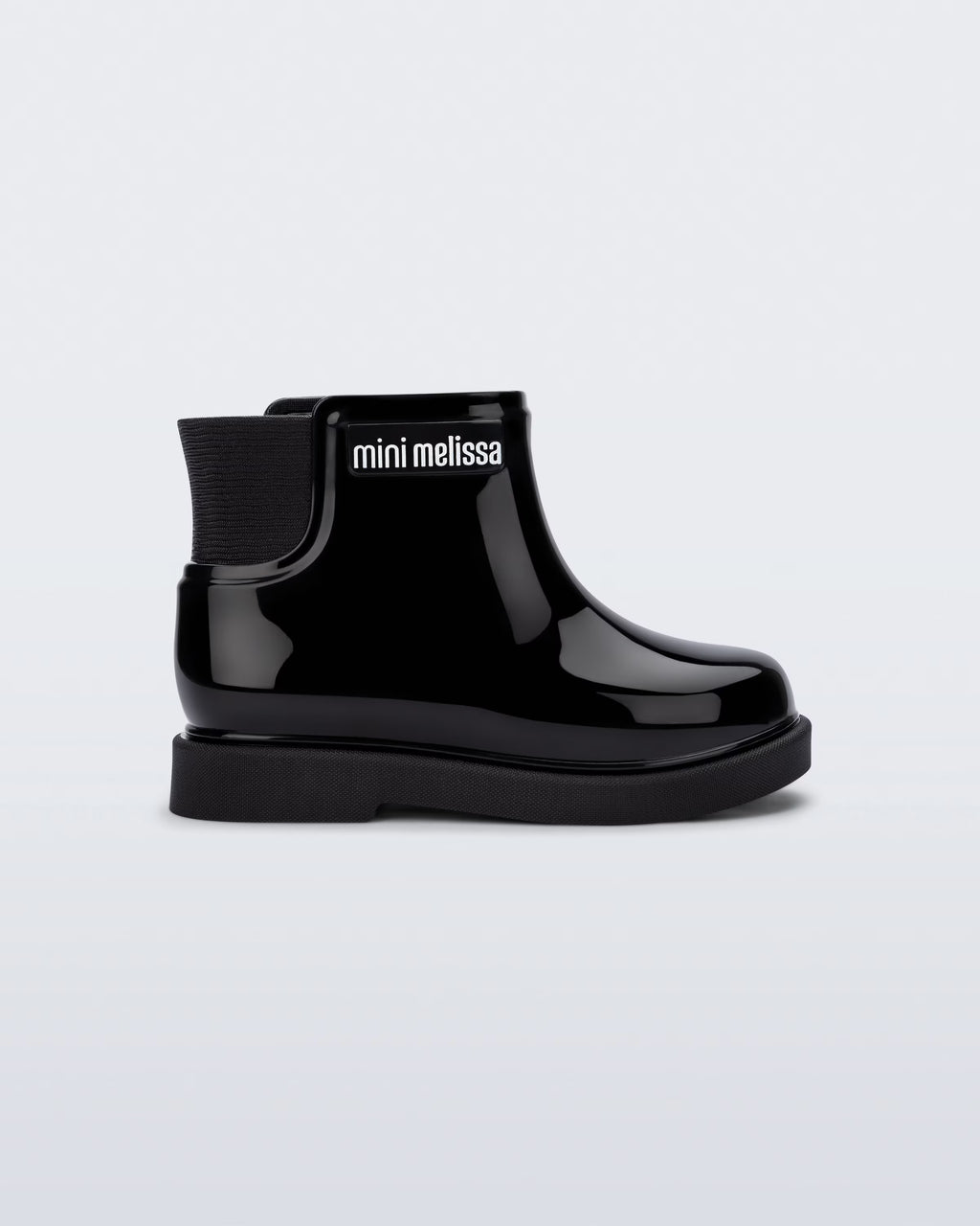 Mini Melissa Chelsea Boot II siyah bilek botu, parlak yüzeyi ve iç fermuar detayıyla yan açıdan görünüyor.