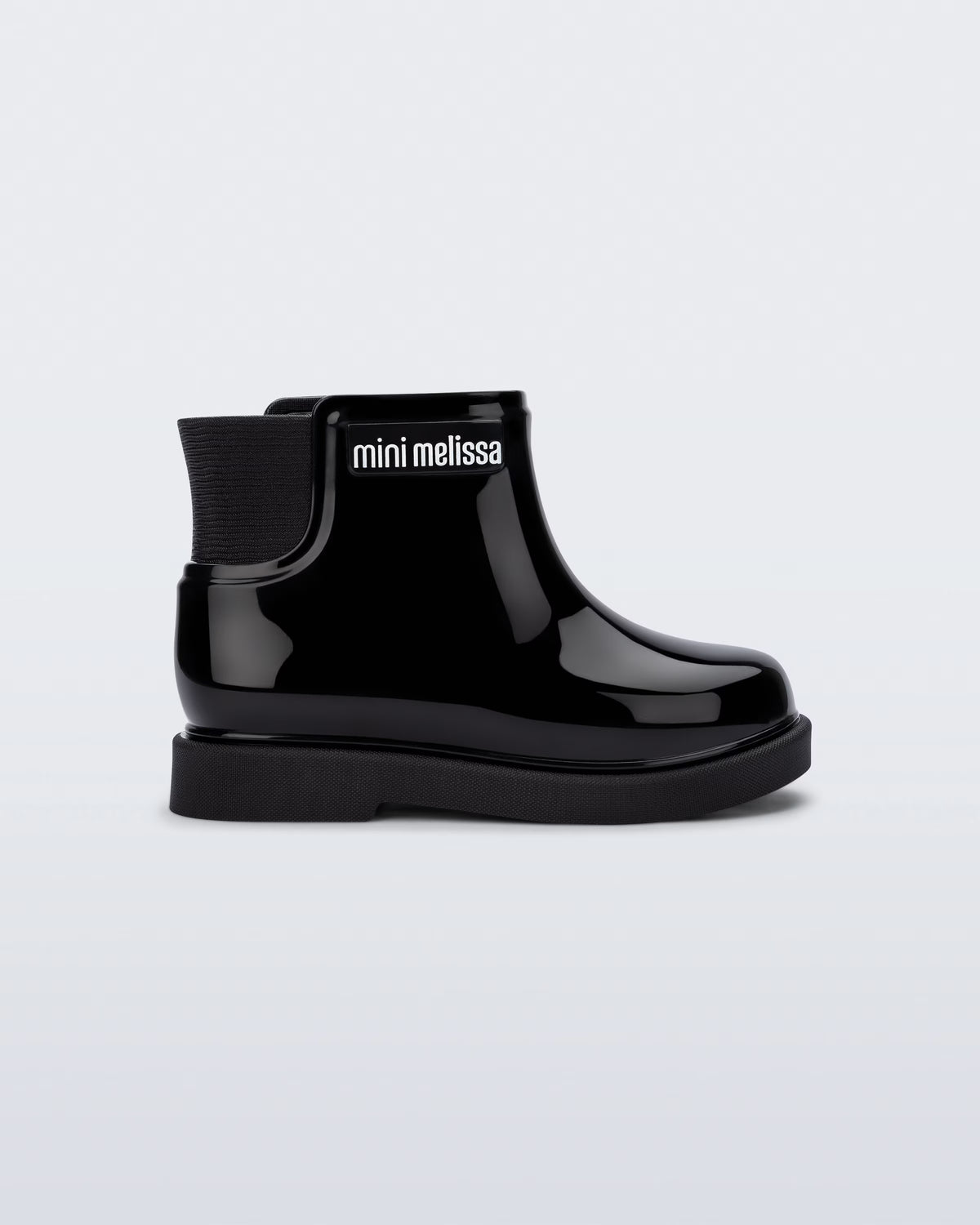 Mini Melissa Chelsea Boot II siyah bilek botu, parlak yüzeyi ve iç fermuar detayıyla yan açıdan görünüyor.