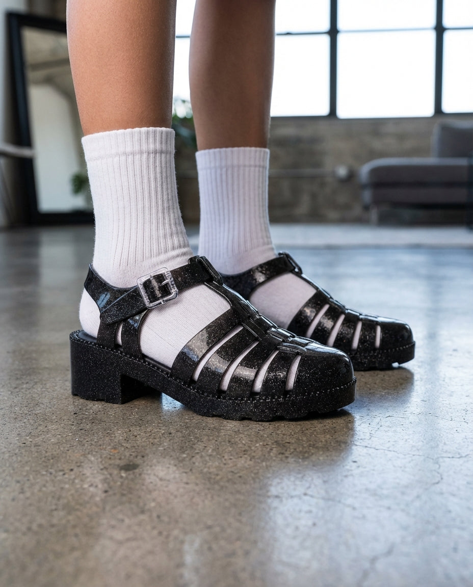 Beyaz soket çorapla kombinlenmiş Mini Melissa simli siyah blok topuklu kız çocuk sandaleti yakın plan