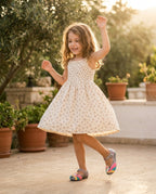 Mini Melissa Unicorn gümüş simli ayakkabı giyen küçük kız, yazlık elbisesiyle bahçede oynarken altın ışıkta