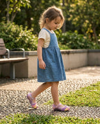 Mini Melissa Unicorn lila simli ayakkabı giyen çocuk bahçede jean elbiseyle yürüyor, günlük konforlu kullanım
