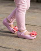 Açık pembe taytla adım atan 2 yaşındaki miniğin ayağını güvenle saran pratik Mini Melissa lila ayakkabı yakın pla
