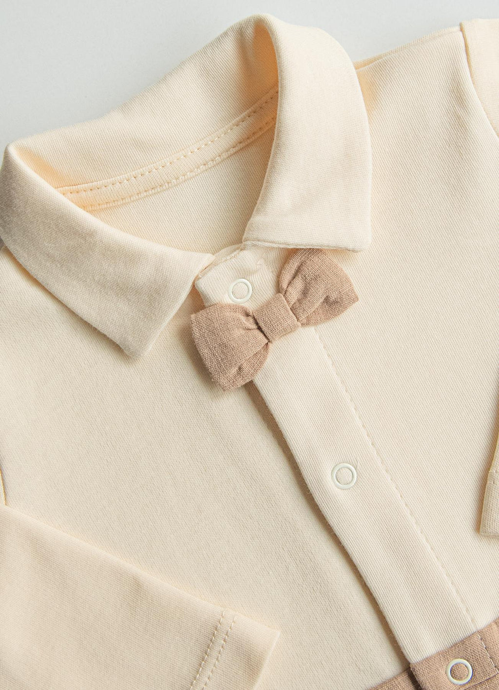 ekru-polo-yaka-papyonlu-organik-bebek-tulumu-detayi