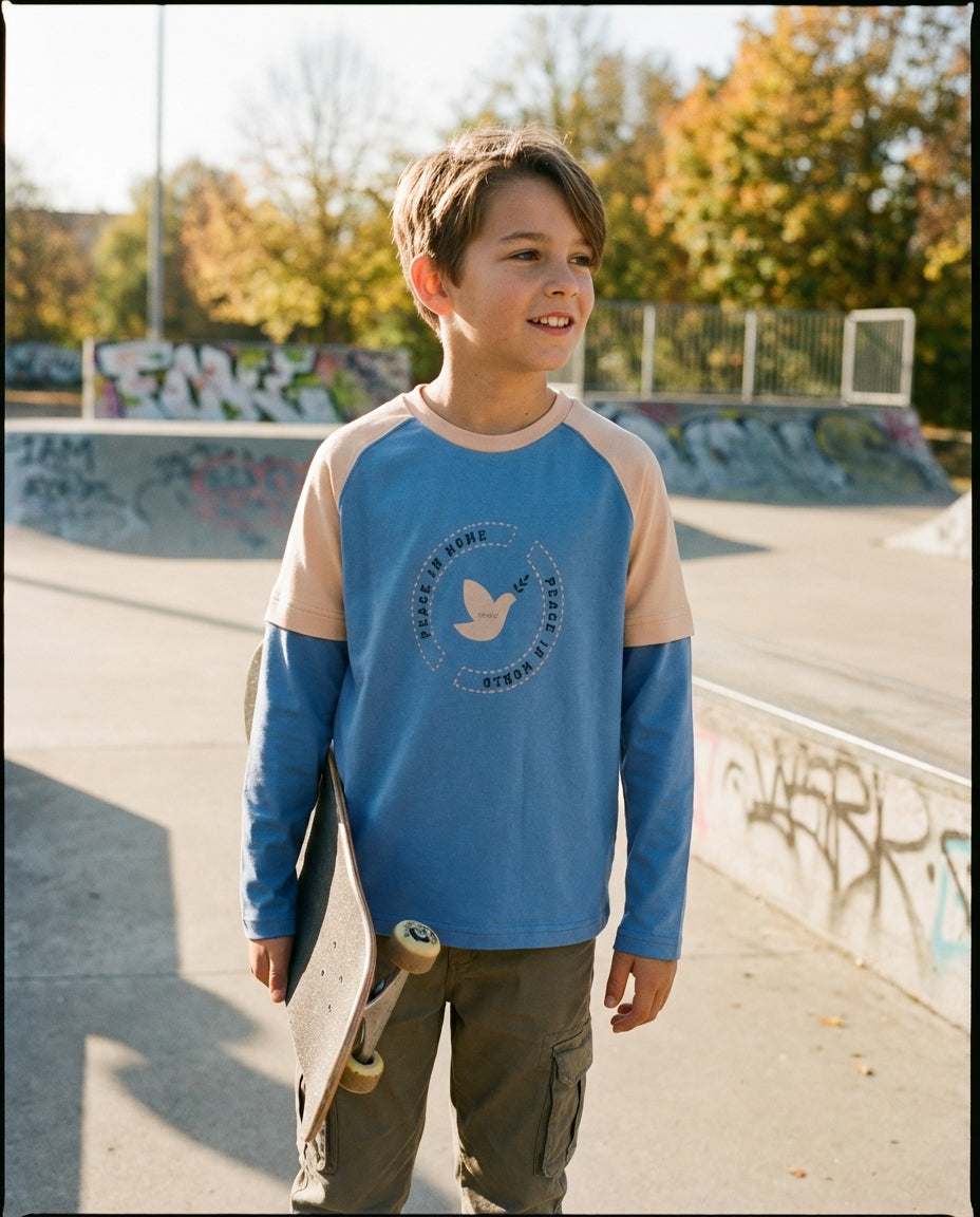 Sokak stilinde kaykay tutan 10-11 yaşındaki erkek çocuğunun üzerindeki Ozmoz çift renk organik sweatshirt