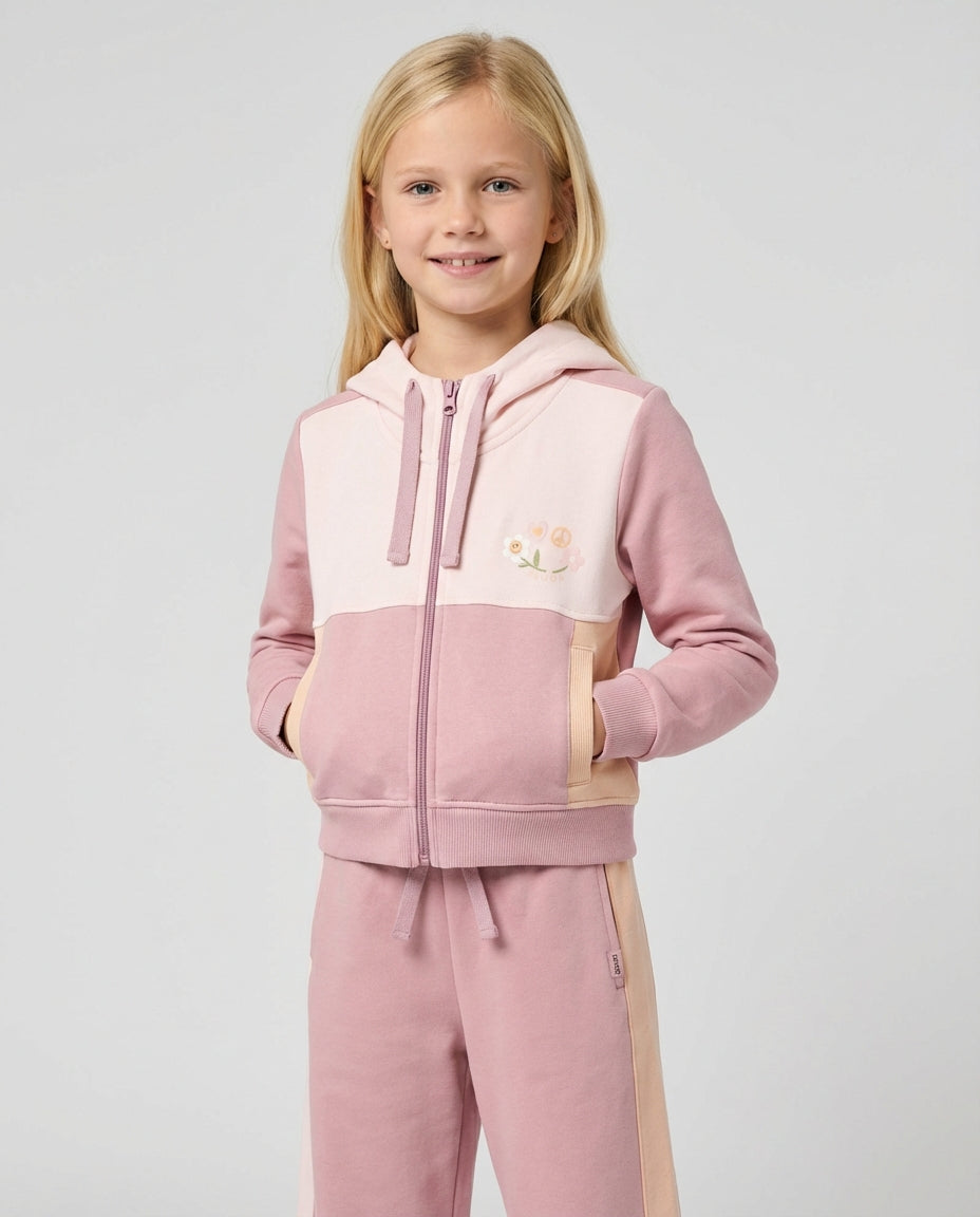 Profesyonel stüdyo ortamında Ozmoz pembe çift renkli organik eşofman takımı giyen sarışın kız çocuğu